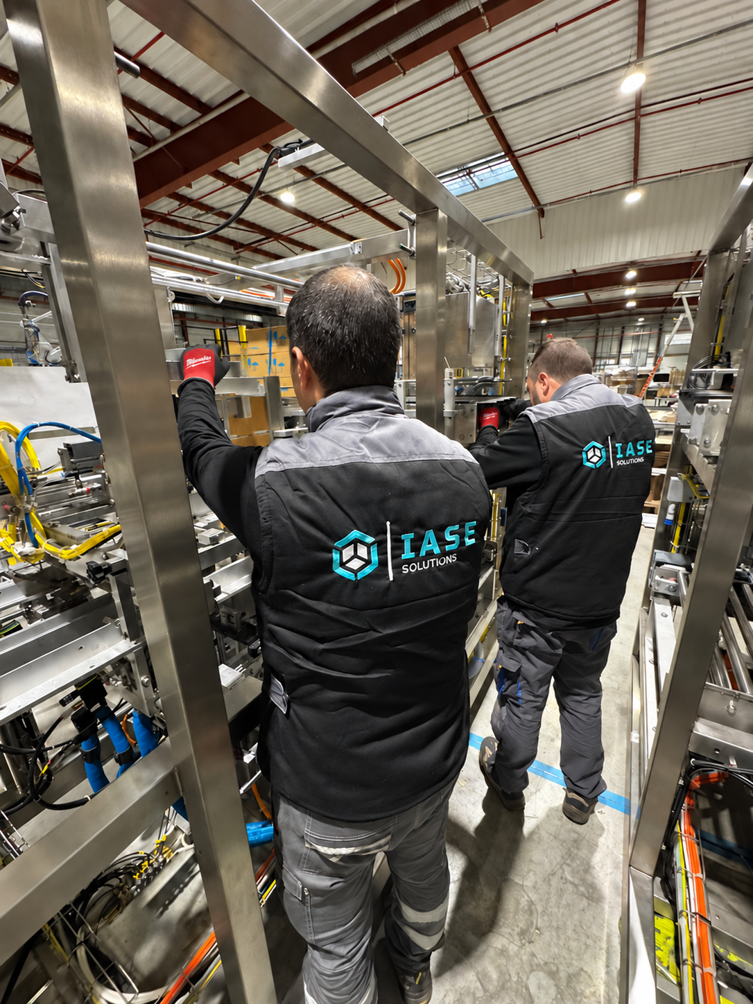 Equipa com uniformes IASE a trabalhar em conjunto na montagem de uma máquina